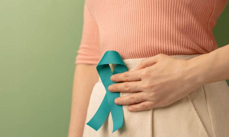 woman holding teal banner to tummy