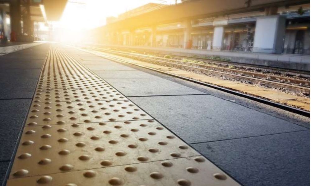 yellow tactile braille on train station platform at sunrise