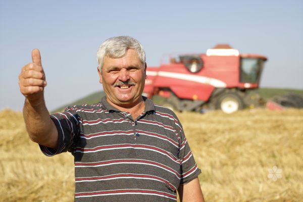 smiling man in front of red tractor