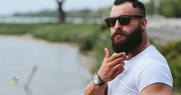 man stroking his lucious beard wearing sunglasses