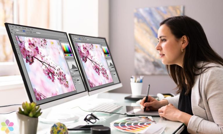 woman sketches while looking at two computer screens of cherry blossoms