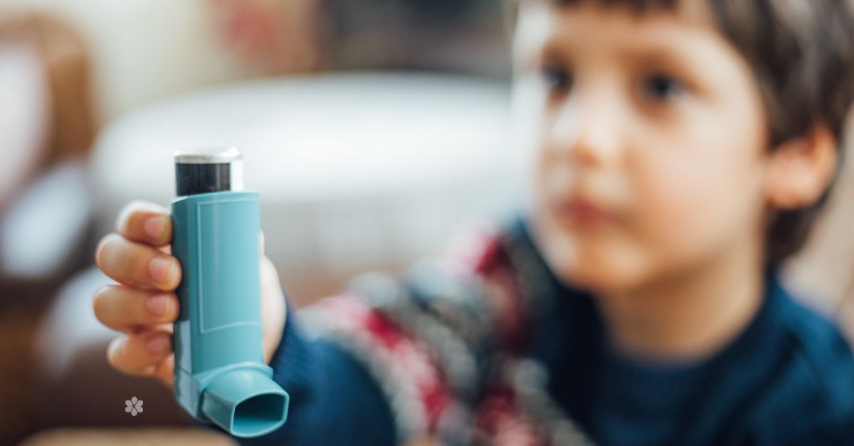 boy extends hand that's holding a blue asthma reliver