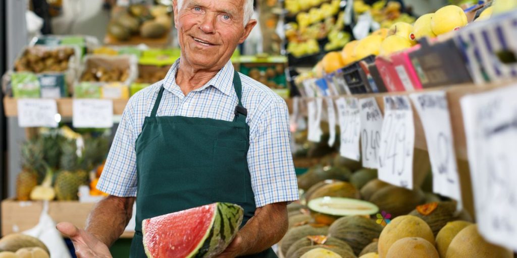 man holding watermelon in green grocer