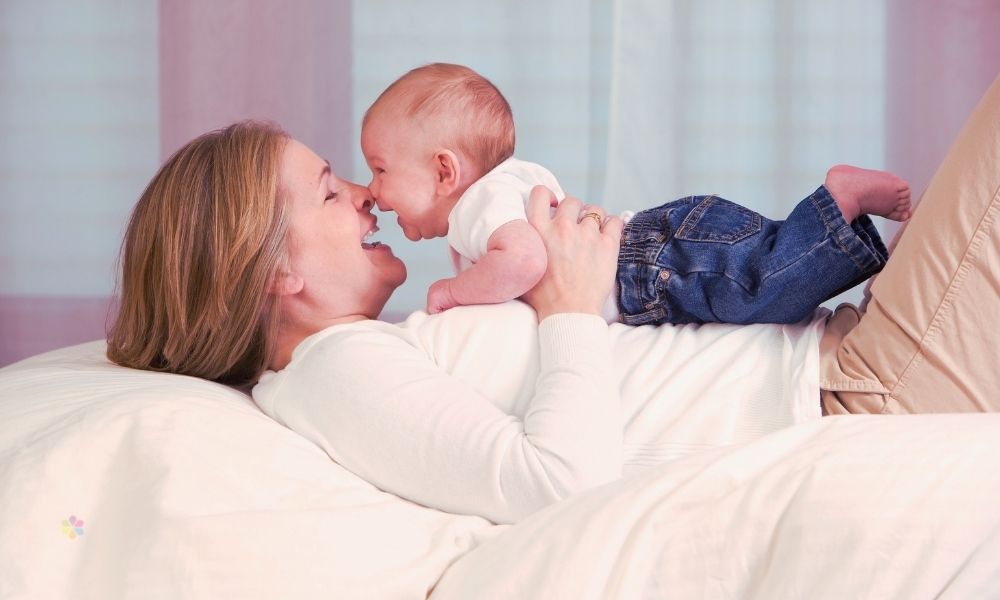 Woman and baby laughing together nose to nose