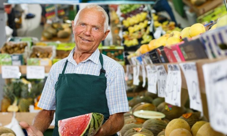 smilibg nab holdng watermelon in fruit shop