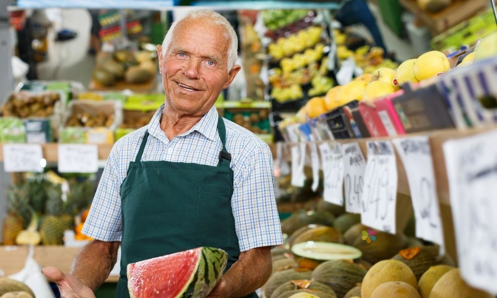 smilibg nab holdng watermelon in fruit shop