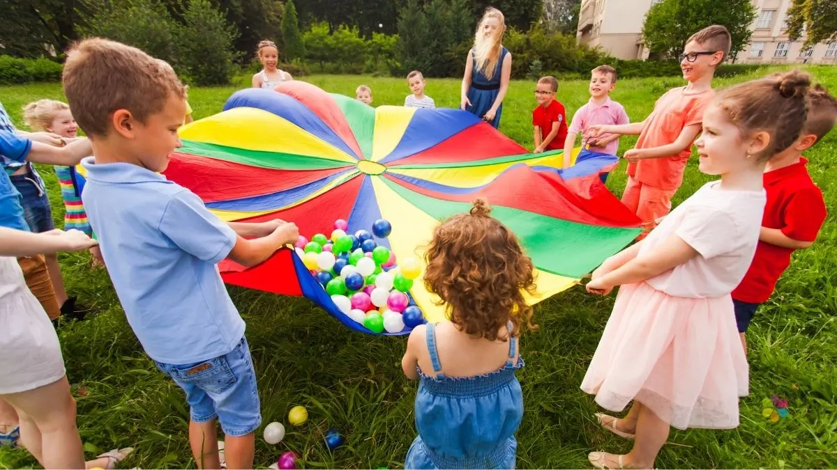 children play with a colourful parachute