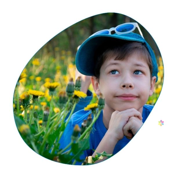 boy in field of flowers looking at the sky