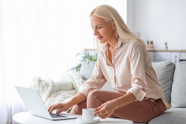 relaxed woman reading computer at home